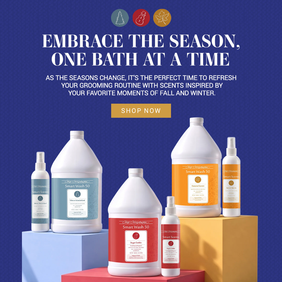 A promotional banner for Chris Christensen SmartWash fall and winter scented bath products, featuring several large plastic jugs and bottles with white, red, and orange labels arranged on blue, yellow, and red pedestals against a dark blue background with white text and a gold 'SHOP NOW' button.